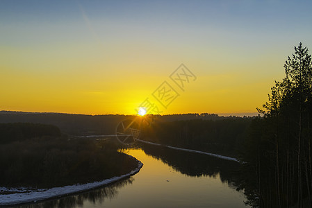 河边的冬天日落溪流蓝色黄色场景天空天气阳光季节太阳树木图片