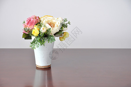 桌子上放着人工花工艺花束玫瑰植物柏科礼物花瓶花朵织物反射图片
