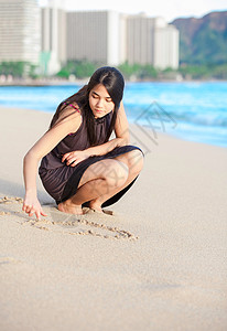 怀基基海滩上两种族少女在沙滩上画画图片