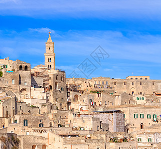 蓝色天空下典型石块和Matera教堂的全天观小窝岩石城市历史性建筑纪念碑场景旅行地标宗教图片