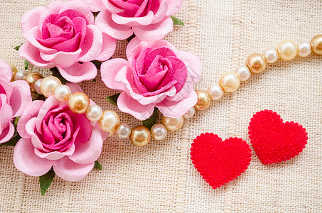 红心和粉红玫瑰 在布料背景图片