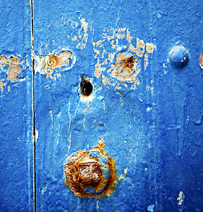蓝色木门和生锈的钉子上的脏漆静脉旅游金属建筑学黄铜指甲阴影盘子雕塑安全图片