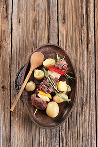 Shish kebab和土豆木勺鹿肉午餐红肉牛肉金属拼盘铸铁胡椒主菜图片