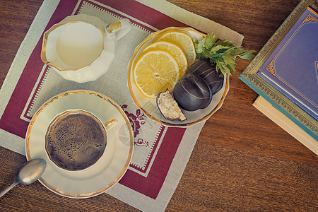静态生活 一小杯黑咖啡在桌子上黑色棕色菜肴餐馆柠檬盘子巧克力蛋糕食物果味图片