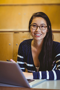 上课时使用笔记本电脑的微笑学生大学女性快乐高等教育校园报告教育技术演讲女士图片