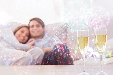 情侣在沙发上躺着的复合图像 里面放着香槟笛子家庭长椅拥抱女士庆典计算机短发活力男性亲密感图片