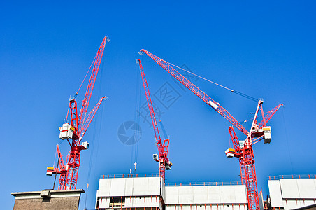 蓝色天空背景的红色建筑起重机送货码头框架项目后勤重量机械港口金属工人图片