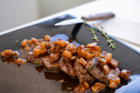 黑盘上加酱汁的猪肉菜肋骨釉面烧烤油炸牛肉文化猪肉午餐熏制酒吧图片