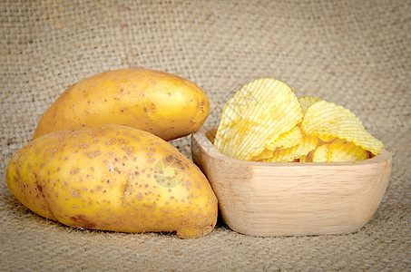 木碗和新鲜土豆中的马铃薯片小吃块茎香料农场蔬菜脂肪植物瓦楞芯片收成图片