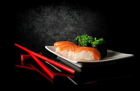 寿司和筷子鱼片反射盘子桌子沙拉食物陶瓷餐厅海鲜午餐图片