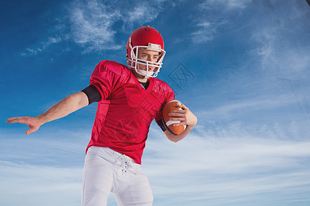 美式足球运动员保护足球的复合形象运动运动服头盔天空竞技男性活动男人专注四分卫图片