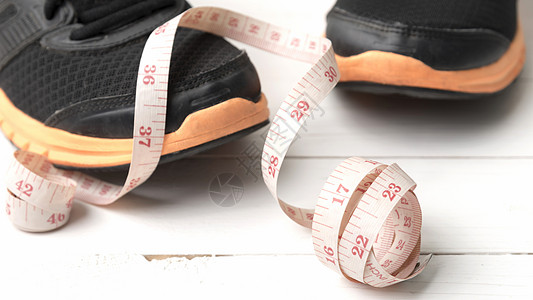 运动鞋和测量胶带重量饮食健身房跑步厘米衣服培训师白色运动训练图片