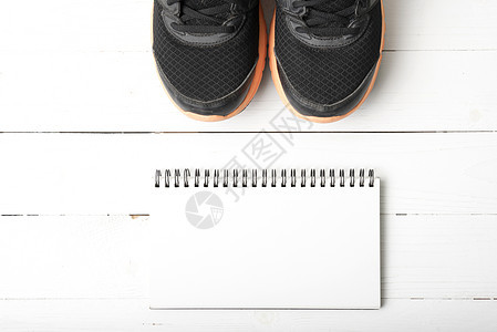 运行鞋子和笔记本饮食重量运动活动瓶子电脑记事本木头跑步训练背景图片