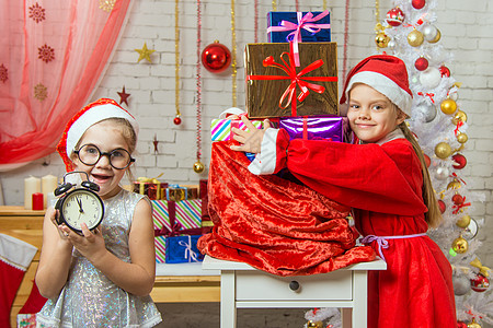 一个 11-55 岁的女孩一直在守望 另一个穿着圣诞老人的衣服 抱着一个装着礼物的袋子图片