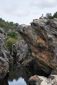 女人在岩石上石头游泳森林绿色树木图片