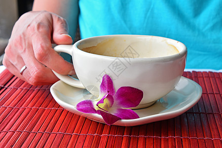 手握着咖啡杯和花朵的妇女拿铁紫色红色已婚咖啡店女士兰花牛奶杯子飞碟图片
