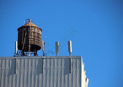 蓝色天空的顶层木制水箱容器图片