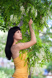 阿卡西亚树开花附近的女孩野花礼物蓝色花朵环境女士享受幸福女性快乐图片