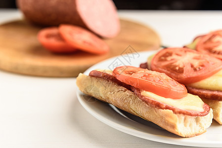 配西红柿的热三明治小吃香肠红色桌子肉类面包食物早餐盘子白色图片