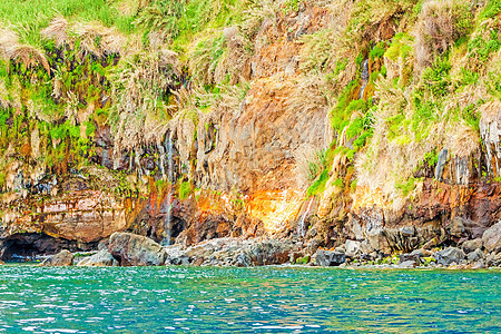 马德拉的多彩岩石悬崖海岸摇滚海岸线岩壁火山表面橙子废料海洋热带旅游图片