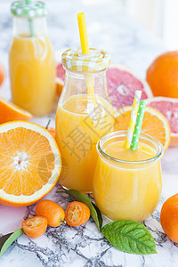 以新鲜柑橘水果制成的果汁柚子果味食物橙汁冰沙维生素营养瓶子黄色压榨图片