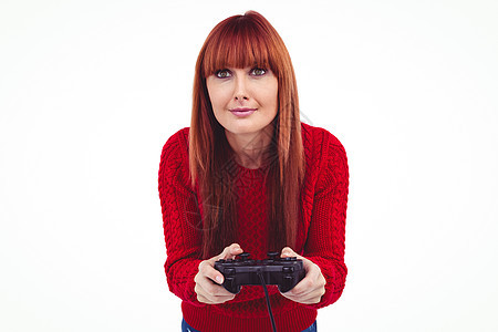 玩电子游戏的妇女微笑着笑着的时装女人游戏刘海休闲安慰服装潮人针织品快乐控制器按钮图片
