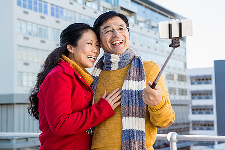 在阳台上自拍的年老一对亚裔夫妇风光女性老年保暖活动耳罩女士快乐感情都市图片