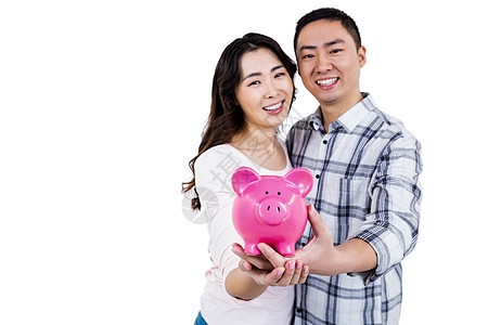 快乐的情侣持有小猪银行的肖像图片