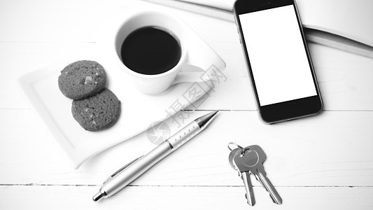 咖啡杯加饼干 手机 笔记本和主要黑白co细胞网络杯子咖啡工作电话钥匙眼镜桌子办公室背景图片
