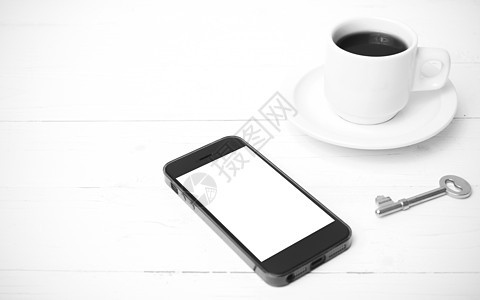 配有电话和黑白主要颜色的咖啡杯网络钥匙杯子笔记本细胞桌子眼镜咖啡办公室工作背景图片
