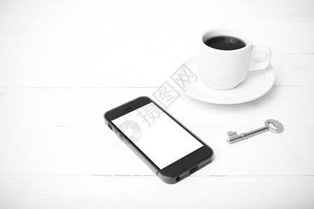 配有电话和黑白主要颜色的咖啡杯笔记本杯子细胞办公室网络咖啡钥匙桌子眼镜工作背景图片