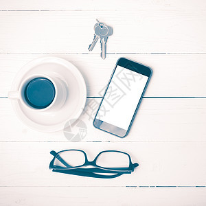 配有电话 眼镜和主要古董风格的咖啡杯网络办公室钥匙咖啡桌子工作笔记本杯子细胞背景图片