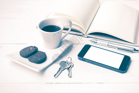 配有饼干 手机 笔记本和主要古董风格的咖啡杯钥匙桌子办公室工作网络眼镜咖啡细胞杯子电话背景图片