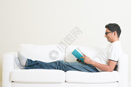 亚洲男子在沙发上读书图片