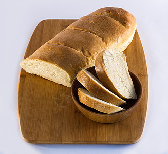 与碗中炸面包的切肉板上的法国面包面包图片