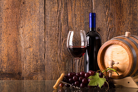 一杯红酒 装瓶子桶葡萄和木制背瓜图片