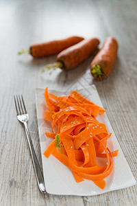 白盘上的胡萝卜沙拉面条白色午餐绿色蔬菜美食盘子橙子木头沙拉图片