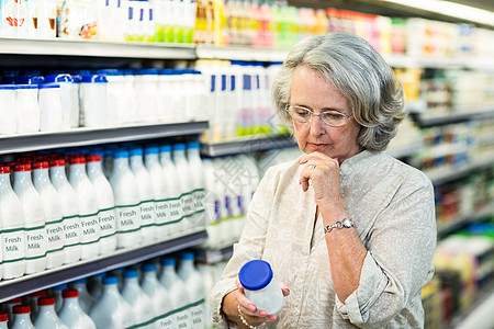 购买牛奶的老年妇女服装购物活动阅读下巴顾客饮食女士商业闲暇图片