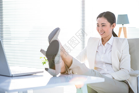 女商务人士在办公桌上用双腿放松办公室女士技术公司电脑旋转椅女性商务微笑快乐图片