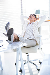 女商务人士在办公桌上用双腿放松人士办公室笔记本套装技术旋转椅公司商务女士划线图片