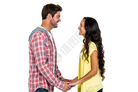 手牵手看着对方的一对微笑的情侣背景图片
