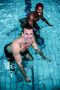 在游泳池中骑自行车的合适男子生活方式护理中心健身房运动员训练混血微笑闲暇有氧运动图片