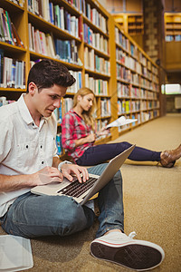 集中在楼层工作的学生大学技术校园地面电脑学习女士男性男人图书馆图片