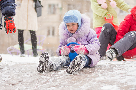5岁女孩在滚动一个冷冻的山丘图片