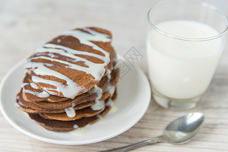 巧克力煎饼加牛奶午餐茶匙奶制品食物盘子饼子水平白色桌子木头图片