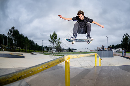 滑板机在做一个ollie青少年沥青冲浪者半管溜冰者男性空气男生活动青年图片