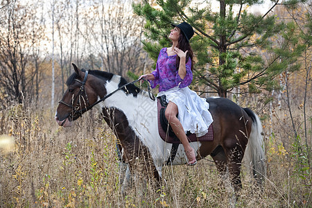 青年妇女与马活动训练闲暇骑术牛仔女士衣服头发森林宠物图片