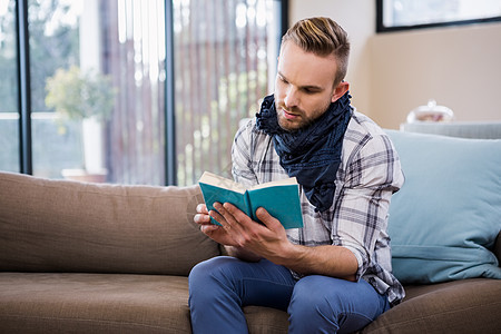 帅哥在沙发上读书服装家庭生活男性文学公寓客厅专注男人休闲阅读图片