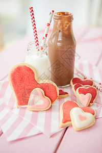 牛奶巧克力粉红饼干和牛奶可可条纹生日瓶子红色款待食物糖果饼干奶瓶背景