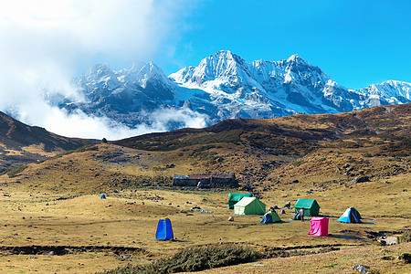 高山顶上有帐篷的营地顶峰冰川岩石蓝色太阳旅行高山高度环境全景图片